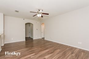 Dallas house for rent - A spacious room with a ceiling fan and wooden flooring.