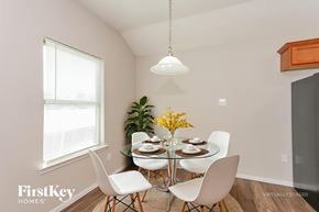 Dallas house for rent - A dining room with a glass table and white chairs.