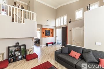Brea house for rent - A living room with a grey couch and a red rug.