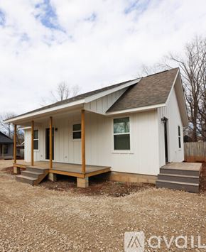 Berryville house for rent - A small white house with a porch and a brown roof.