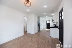 Berryville house for rent - A large empty room with wooden floors and a ceiling light.