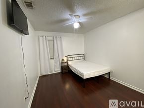 Moreno Valley house for rent - A bedroom with a large bed and a ceiling fan.