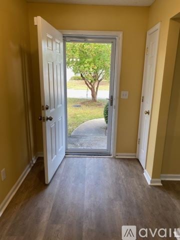 Columbia house for rent - A black refrigerator in a kitchen with white cabinets and a black and white floor.