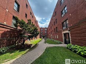 Chicago apartment for rent - A brick building with a tree and a walkway in front.