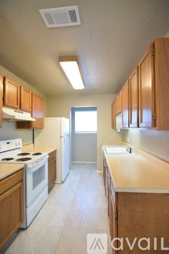 Killeen house for rent - A kitchen with wooden cabinets and a white stove top oven.