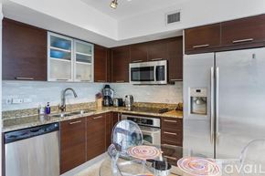 Miami condo for rent - A kitchen with a refrigerator, microwave, and oven.