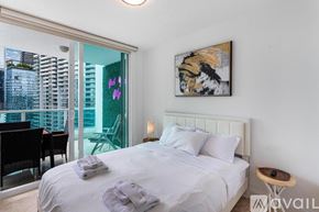 Miami condo for rent - A bedroom with a large bed and a painting on the wall.