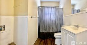 Lubbock house for rent - A bathroom with a toilet, sink, and shower curtain.