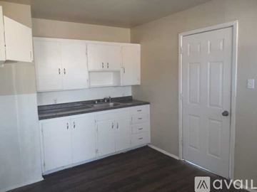 Lubbock house for rent - A kitchen with white cabinets and a black countertop.