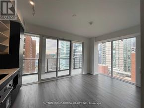 Toronto (Bay Street Corridor) condo for rent - A spacious room with large windows and wooden flooring.