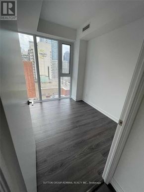 Toronto (Bay Street Corridor) condo for rent - A room with a view of a cityscape through a window.