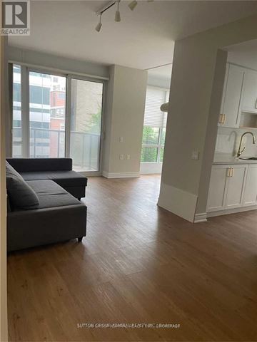 Toronto (Church-Yonge Corridor) condo for rent - A living room with a grey couch and wooden floors.