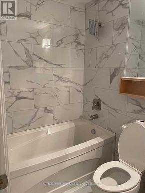 Toronto (Church-Yonge Corridor) condo for rent - A bathroom with a marble tile wall and a white toilet.