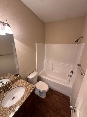 Centerton house for rent - A small bathroom with a toilet, sink, and bathtub.