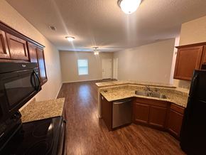 Centerton house for rent - A kitchen with a granite countertop and stainless steel appliances.