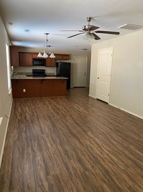 Centerton house for rent - A kitchen with wooden floors and a ceiling fan.