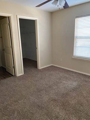 Centerton house for rent - A room with a ceiling fan and a window with blinds.