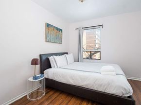 Toronto apartment for rent - A bedroom with a bed, pillows, a lamp, and a painting on the wall.