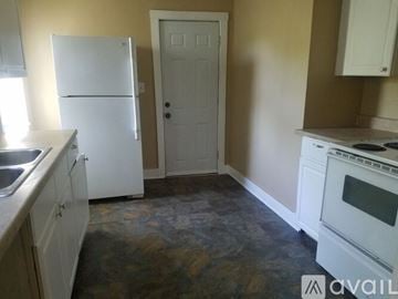 Kansas City house for rent - A kitchen with a white fridge, white door, and a white oven.