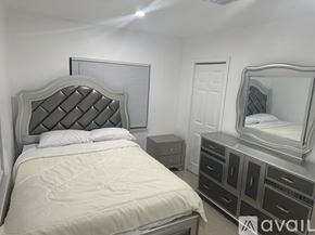 Miramar apartment for rent - A bedroom with a large bed, a vanity with a mirror, and a nightstand.