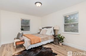 Cincinnati apartment for rent - A bedroom with a bed, two lamps, and a cowhide rug.