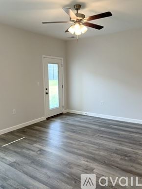 Bowling Green apartment for rent - A room with a ceiling fan and a door leading outside.