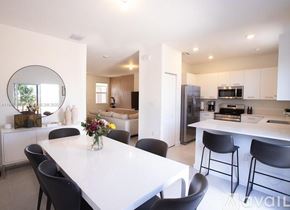 Miami townhouse for rent - A modern kitchen with a dining table and chairs.