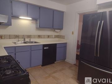 Harahan house for rent - A kitchen with purple cabinets and a black stove top.