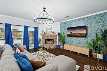 Burleson house for rent - A living room with a grey couch and a fireplace.