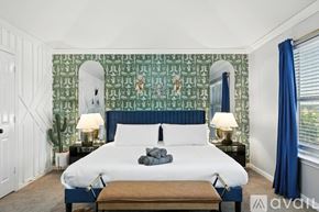 Burleson house for rent - A bedroom with a large bed and a green patterned wallpaper.