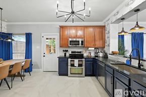 Burleson house for rent - A modern kitchen with wooden cabinets and a blue accent wall.