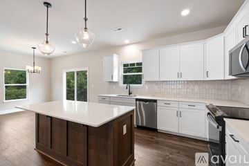 Asheville house for rent - A kitchen with white cabinets and a wooden island.