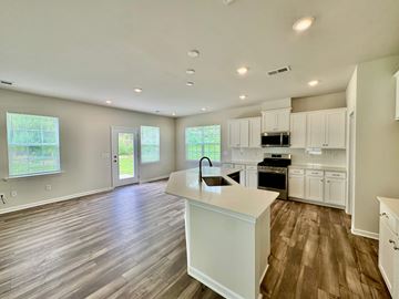 Taylors house for rent - A kitchen with white cabinets and a wooden floor.
