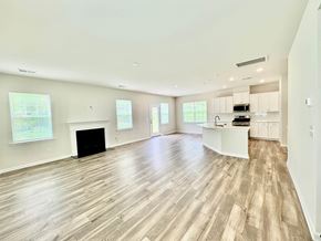Taylors house for rent - A spacious living room with a fireplace and hardwood floors.