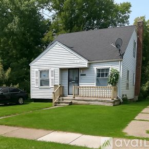 Detroit house for rent - A small house with a porch and a car parked in front.