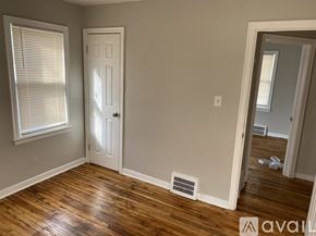 Detroit house for rent - A room with wooden floors and a white door.