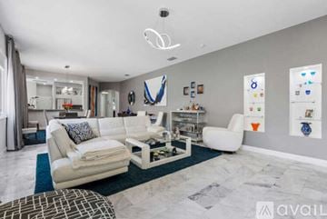 Bradenton house for rent - A modern living room with white furniture and a blue rug.