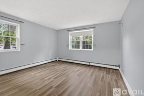 Billerica condo for rent - A kitchen with white appliances and wooden chairs.