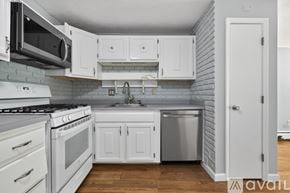 Billerica condo for rent - A kitchen with white cabinets and a stove top oven.