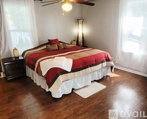 Moline apartment for rent - A bedroom with a bed covered in a red and white comforter.