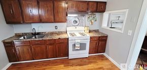 Moline apartment for rent - A kitchen with wooden cabinets and a white oven.