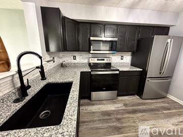 Indianapolis house for rent - A kitchen with black cabinets and a granite countertop.