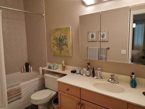 Edmonton apartment for rent - A bathroom with a toilet, sink, and mirror.