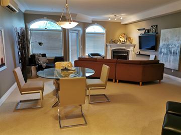 Edmonton apartment for rent - A living room with a glass table and chairs.