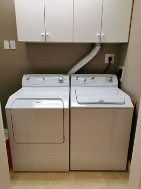 Edmonton apartment for rent - A white washing machine and dryer in a small laundry room.