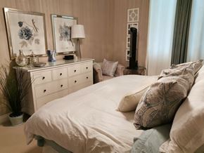 Edmonton apartment for rent - A bedroom with a large bed, a dresser with a mirror, and a plant.