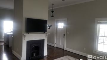 Greenville house for rent - A living room with a fireplace and a television mounted above it.