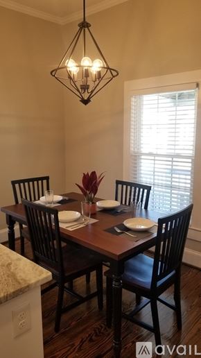 Greenville house for rent - A dining room with a table set for two and a chandelier hanging from the ceiling.