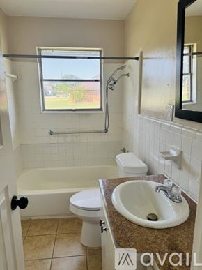 Hutchins house for rent - A bathroom with a tub, toilet, sink, and mirror.