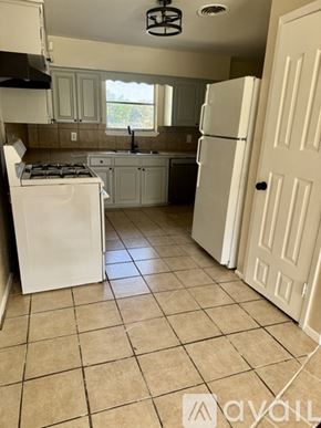 Hutchins house for rent - A kitchen with a white fridge and a white door.
